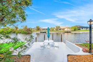 a table with a blue object on it next to a lake at Three Palms Retreat in Cape Coral