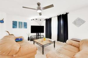 a living room with two couches and a tv at Three Palms Retreat in Cape Coral