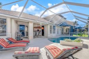 a patio with chairs and a swimming pool at Sable Retreat in Cape Coral