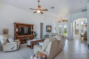 a living room with couches and a flat screen tv at Sable Retreat in Cape Coral +29 photos