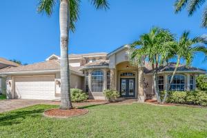a house with palm trees in front of it at Sable Retreat in Cape Coral