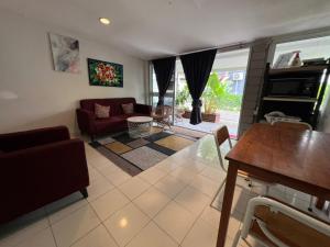 a living room with a couch and a table at Little Chenang Cottage Motel Langkawi in Pantai Cenang