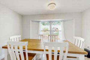 a dining room with a wooden table and white chairs at The Flip Flop Stop in Naples