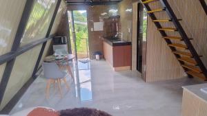 a room with a staircase and a table and a kitchen at Chalés Alto Caparaó in Caparaó Velho