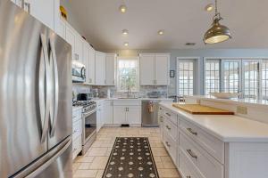 a kitchen with white cabinets and a stainless steel refrigerator at Rehoboth Beach --- 21163 Bayview Rd. in Dewey Beach