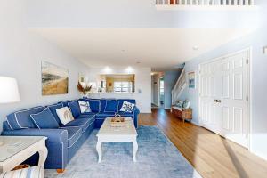 a living room with a blue couch and a table at Bethany Bay --- 37182 Harbor Dr #2606 in Ocean View
