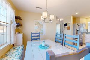 a kitchen with a dining table and blue chairs at Bethany Bay --- 37182 Harbor Dr #2606 in Ocean View