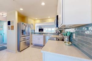 a kitchen with a stainless steel refrigerator and white cabinets at Bethany Bay --- 37182 Harbor Dr #2606 in Ocean View +32 photos