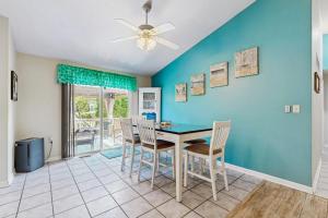 a dining room with a blue wall and a table and chairs at Ocean Way Estates - 32563 W Riga Dr in Ocean View