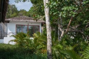 a small white house with a window in a garden at Anaya Koh Rong in Koh Rong Island