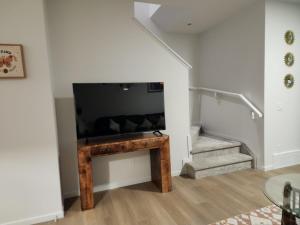 a living room with a flat screen tv and stairs at Edmonton 3BR House in Edmonton