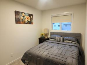 a bedroom with a bed with a painting on the wall at Edmonton 3BR House in Edmonton