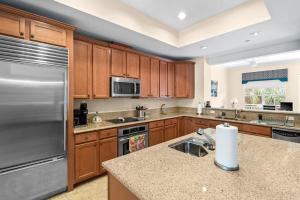 a kitchen with wooden cabinets and a stainless steel refrigerator at White Coral in Placida