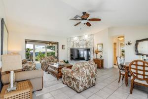 a living room with a couch and a tv at Madagascar Palm in Marco Island