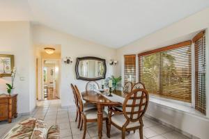 a dining room with a table and chairs and a mirror at Madagascar Palm in Marco Island