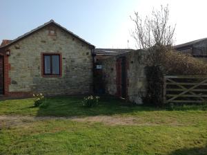 a stone house with a fence and a yard at Stable Cottages in Cowes