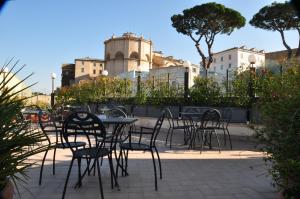 eine Gruppe von Tischen und Stühlen auf einer Terrasse in der Unterkunft Tmark Hotel Vaticano in Rom