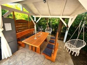 a patio with a wooden table and swing chairs at Villa Forko Luxury Spa Near Paradise Beach in Lopar