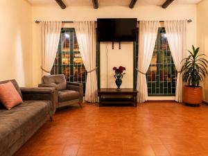 a living room with a couch and a tv at Hotel Altair in Villa de Leyva