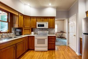 a kitchen with wooden cabinets and a white stove top oven at Salt Pond --- 669 Bethany Loop in Bethany Beach