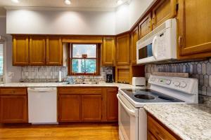 a kitchen with white appliances and wooden cabinets at Salt Pond --- 669 Bethany Loop in Bethany Beach