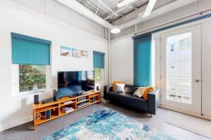 a living room with a couch and a flat screen tv at Rehoboth Beach -- Forj Lofts #8 in Rehoboth Beach