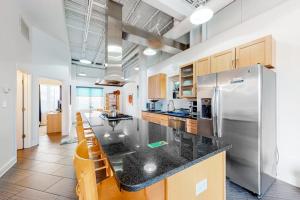 a kitchen with a stainless steel refrigerator and wooden cabinets at Rehoboth Beach -- Forj Lofts #8 in Rehoboth Beach +25 photos