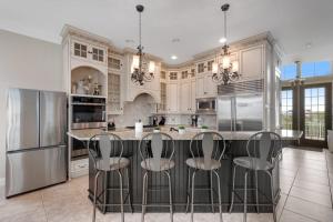 a kitchen with white cabinets and a island with bar stools at Edgewater Acres --- 38874 Old Lighthouse Rd in Selbyville +47 photos
