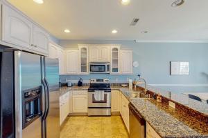 a kitchen with white cabinets and stainless steel appliances at The Tides --- 19979 Sandy Bottom Cir, Unit #502 in Rehoboth Beach +13 photos