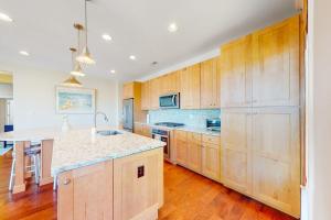 a kitchen with wooden cabinets and a counter top at Watermark North --- 38918 Silver Sands Dr in Bethany Beach +28 photos