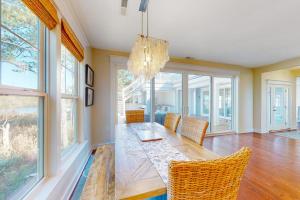a dining room with a table and chairs and windows at Watermark North --- 38918 Silver Sands Dr in Bethany Beach