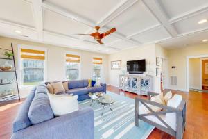 a living room with a blue couch and a ceiling fan at Watermark North --- 38918 Silver Sands Dr in Bethany Beach