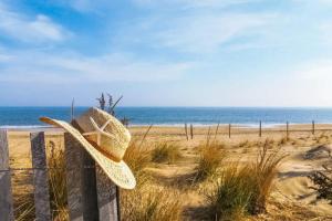 a straw hat sitting on a fence at the beach at Rehoboth Beach --- 18 Sabrina Dr in Lewes