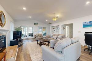 a living room with a couch and a tv at Salt Pond - 1 Heron Ct in Bethany Beach