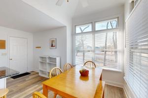 a dining room with a wooden table and a window at Salt Pond - 1 Heron Ct in Bethany Beach