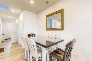 a dining room with a table with chairs and a mirror at Millville By The Sea in Millville