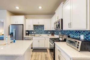 a kitchen with white cabinets and a stove top oven at Millville By The Sea in Millville