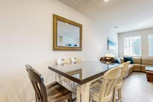 a dining room with a table and chairs and a mirror at Millville By The Sea in Millville