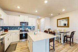 a kitchen with white cabinets and a table and chairs at Millville By The Sea in Millville +34 photos
