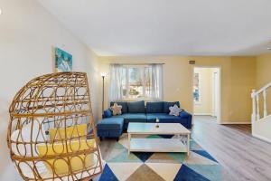 a living room with a blue couch and a table at Bethany Pines - 431 Bethany Pines in Bethany Beach