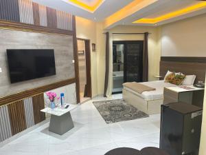 a hotel room with a bed and a television at Résidence MBK in Ziguinchor
