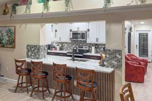 a kitchen with a counter and some bar stools at Mango House in Naples +16 photos