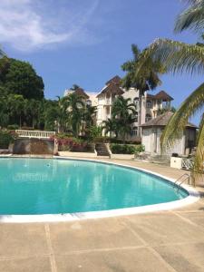 a large swimming pool in front of a house at Sky Castles Apt J3 in Ocho Rios