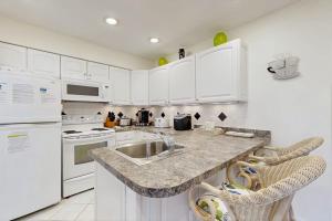 a kitchen with white cabinets and a sink and appliances at Mallard Lakes - 38082 Mockingbird Ln in Selbyville