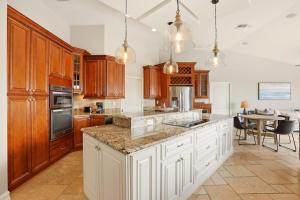 a large kitchen with white cabinets and a table at Marco Paradise in Marco Island