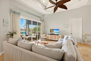 a living room with a large couch and a ceiling fan at Marco Paradise in Marco Island