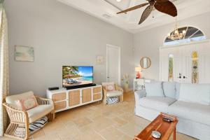 a living room with a couch and a tv at Marco Paradise in Marco Island