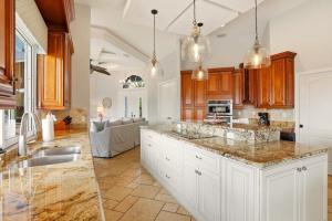 a kitchen with white cabinets and marble counter tops at Marco Paradise in Marco Island +49 photos