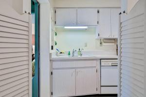 a kitchen with white cabinets and a sink at Tarpon Lagoon in Port Charlotte