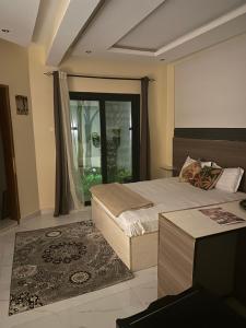 a bedroom with two beds and a large window at Résidence MBK in Ziguinchor